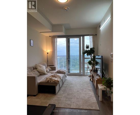 A well-lit, spacious bedroom with a large bed and a view of the outdoors through the sliding glass doors.