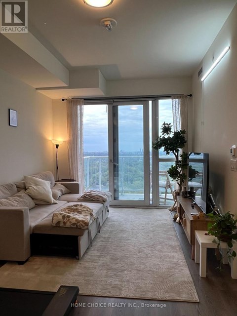 A well-lit, spacious bedroom with a large bed and a view of the outdoors through the sliding glass doors.