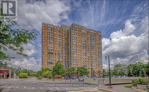 A large apartment building with a parking lot in front.