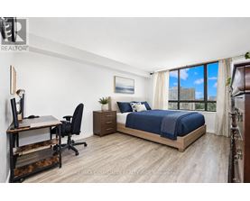 A bedroom with two beds and a desk.
