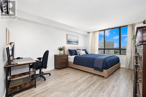 A bedroom with two beds and a desk.