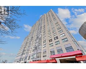 A tall building with a red awning at the entrance.