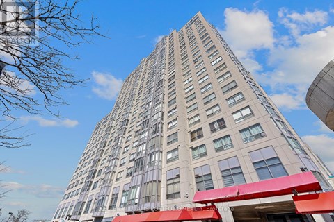A tall building with a red awning at the entrance.
