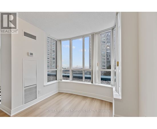 A room with a large window overlooking a cityscape.