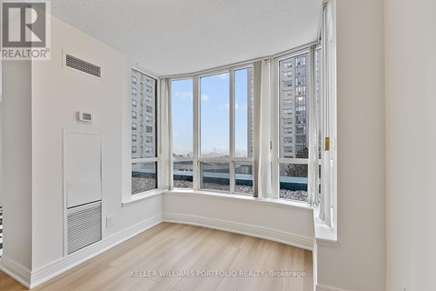 A room with a large window overlooking a cityscape.