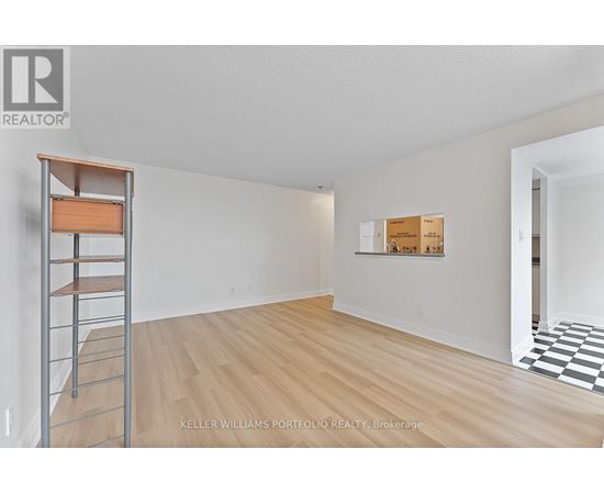 A room with a wooden floor and a ladder against the wall.