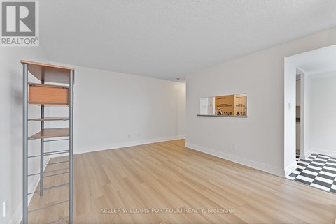 A room with a wooden floor and a ladder against the wall.