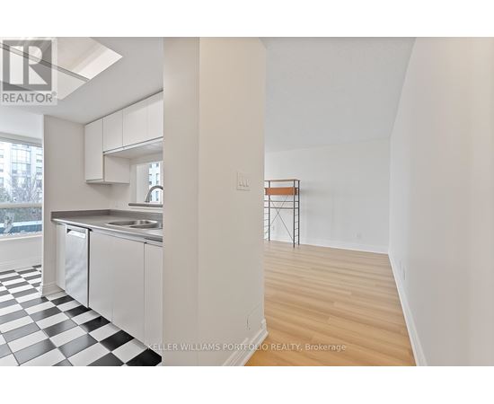 A kitchen with a checkered floor and a white wall.