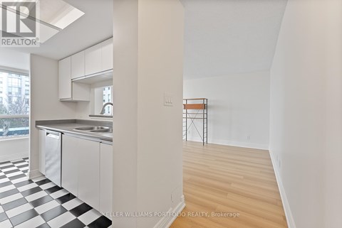 A kitchen with a checkered floor and a white wall.