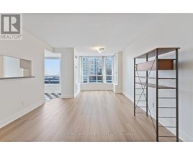 A spacious room with wooden flooring and a large window overlooking a cityscape.