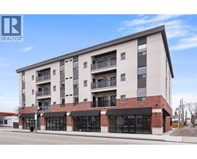 A modern apartment building with a brick facade and multiple balconies.