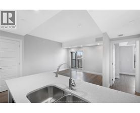 A modern kitchen with a stainless steel sink and faucet.