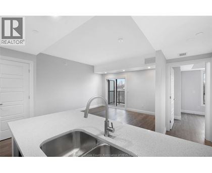 A modern kitchen with a stainless steel sink and faucet.