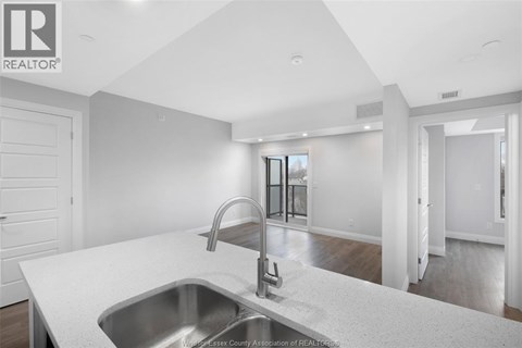 A modern kitchen with a stainless steel sink and faucet.