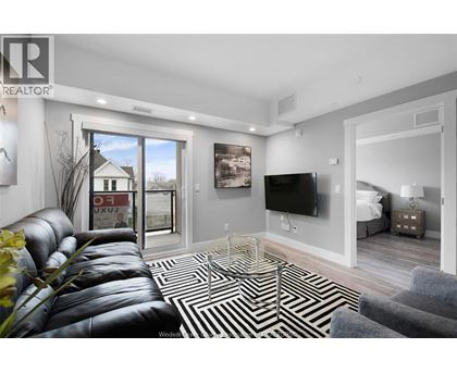 A living room with a leather couch and a television.