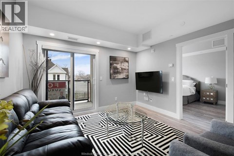 A living room with a leather couch and a television.