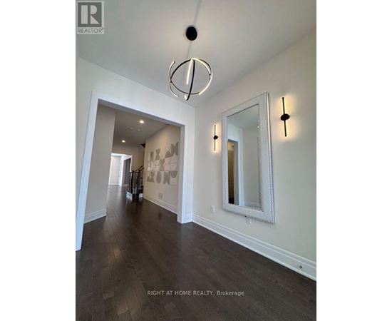 A hallway with a large mirror and lights on the wall.