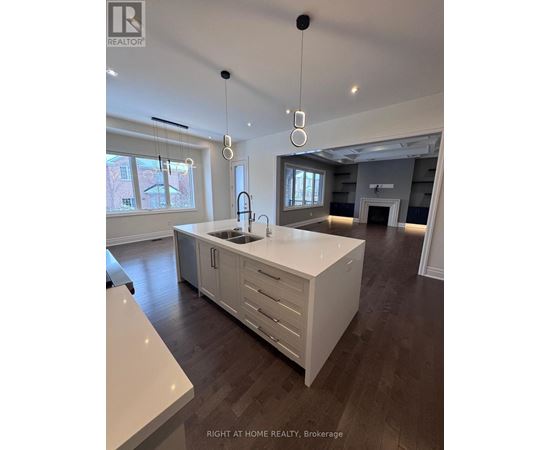 A modern kitchen with a large island and pendant lights.