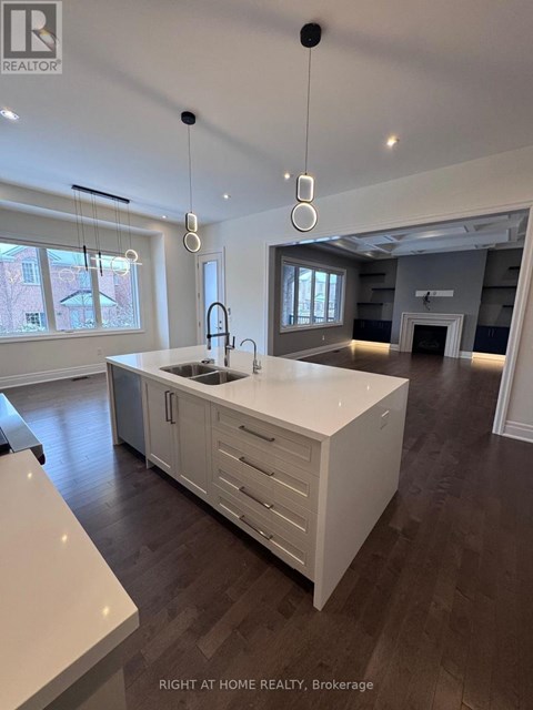 A modern kitchen with a large island and pendant lights.