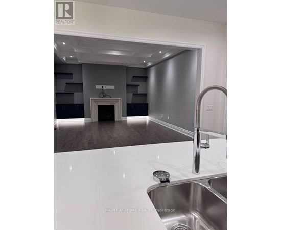 A modern kitchen with a stainless steel sink and a white countertop.