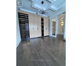 A spacious room with wooden floors and a ceiling fan.