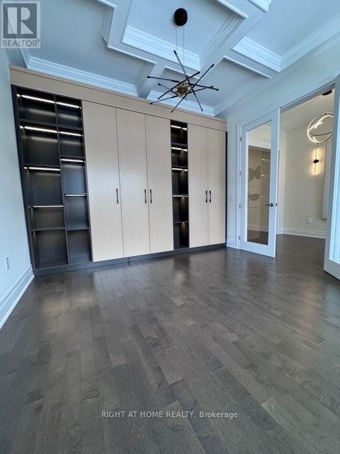 A spacious room with wooden floors and a ceiling fan.