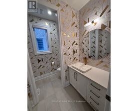 A bathroom with a tiled wall and a round mirror.