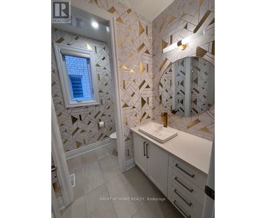 A bathroom with a tiled wall and a round mirror.