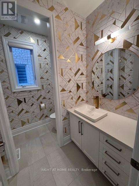 A bathroom with a tiled wall and a round mirror.
