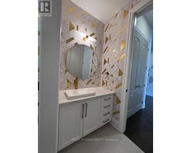 A bathroom with a sink and a mirror with a gold frame.