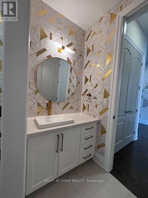 A bathroom with a sink and a mirror with a gold frame.