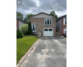 A house with a grey garage door and a driveway in front.