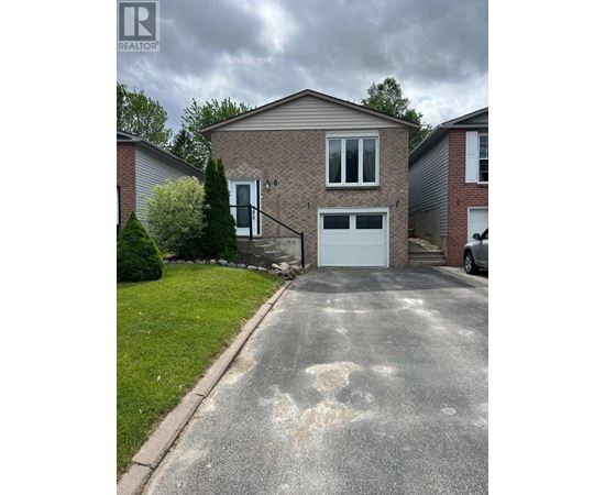 A house with a grey garage door and a driveway in front.