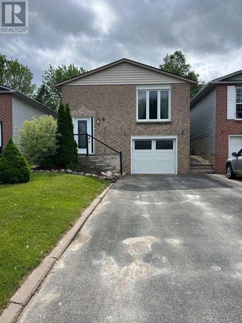 A house with a grey garage door and a driveway in front.