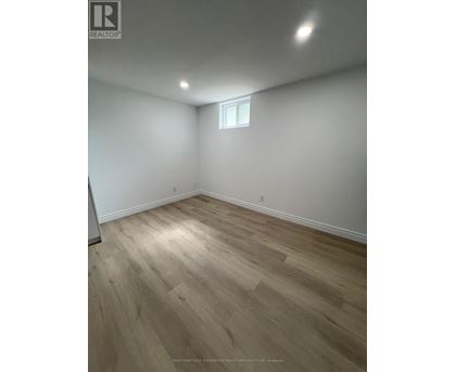 A room with wooden flooring and a window.