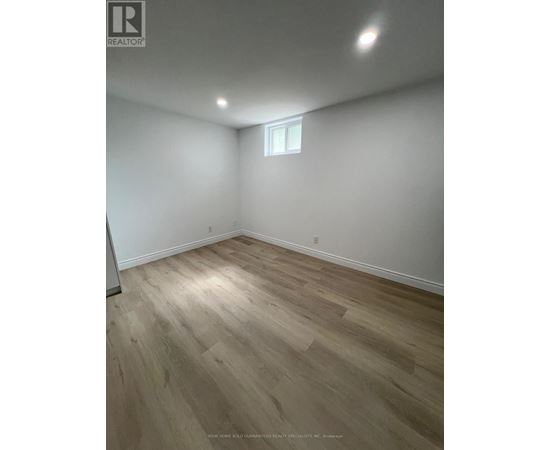 A room with wooden flooring and a window.