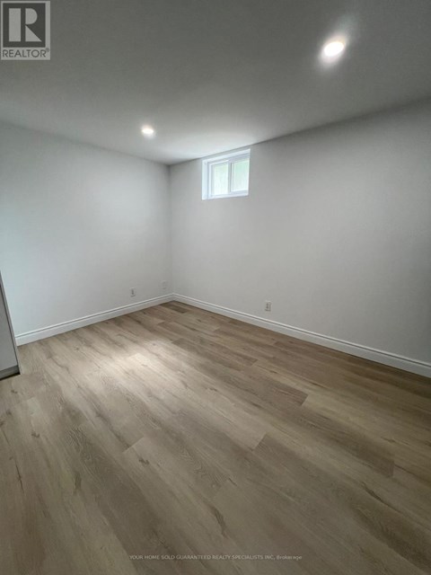 A room with wooden flooring and a window.