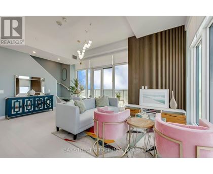 A living room with a pink chair and a white couch.