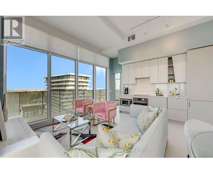 A modern living room with a view of the cityscape outside the large windows.