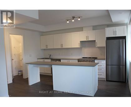 A kitchen with white cabinets and a stainless steel refrigerator.