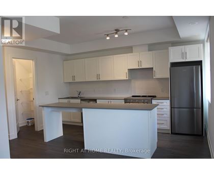 A kitchen with white cabinets and a refrigerator.