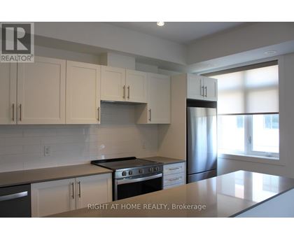 A kitchen with white cabinets and a stainless steel refrigerator.