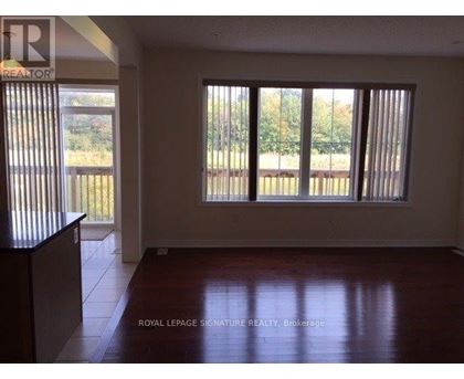 A room with a large window and wooden flooring.