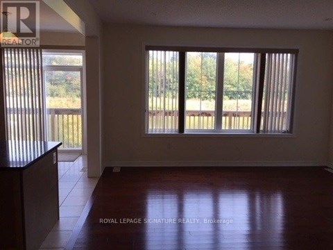 A room with a large window and wooden flooring.