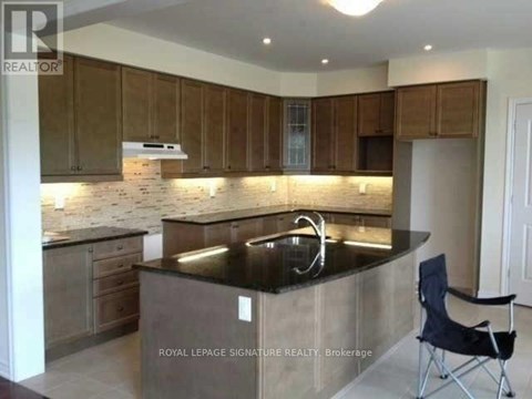 A kitchen with wooden cabinets and a black countertop.