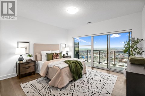 A bedroom with a large bed and a view of the city.