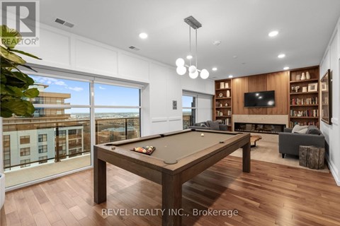 A well-lit room with a pool table and a view of the city.