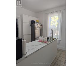 A kitchen with a white counter top and a refrigerator.