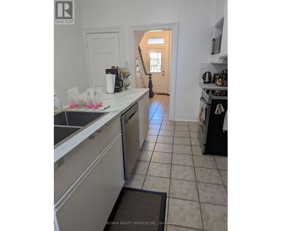 A kitchen with a sink and a door in the background.