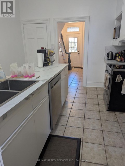 A kitchen with a sink and a door in the background.